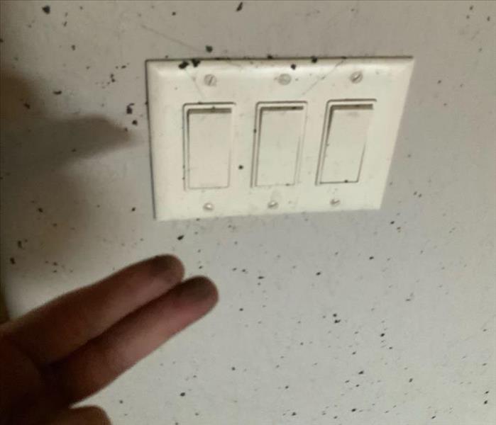wall and light switches covered in black soot