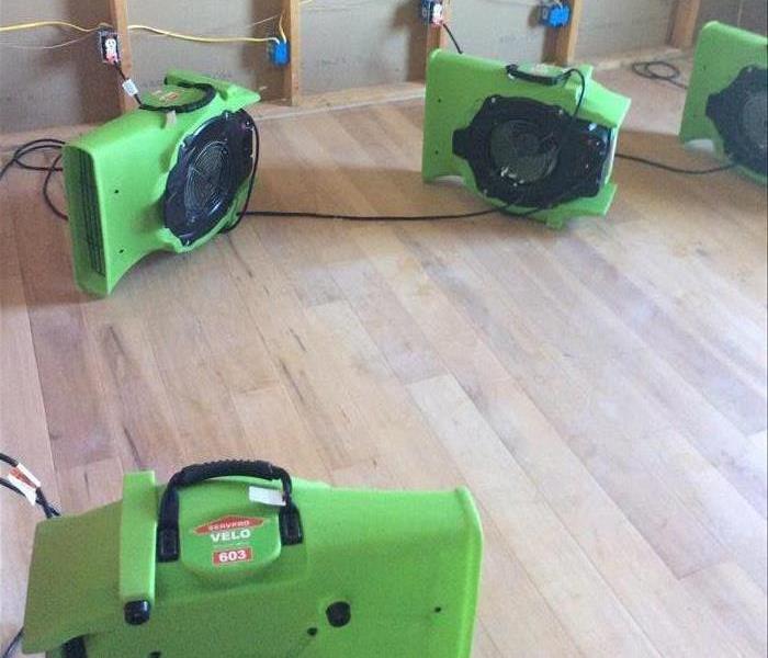 wood floor, bare stud walls, green equipment