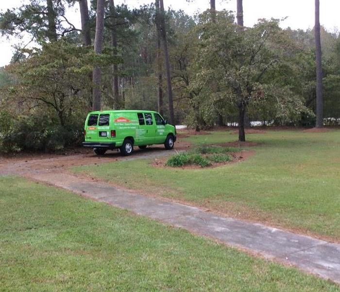 green woodsy area with green van